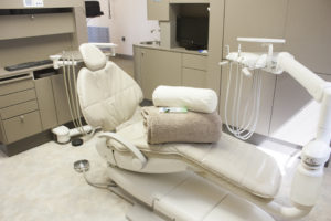 Dentistry By Design Dental Suite with patient chair and a neck pillow and blanket