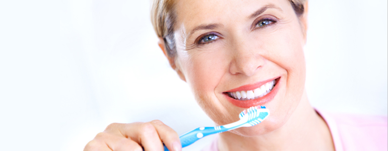 Woman holding a toothbrush towards her mouth